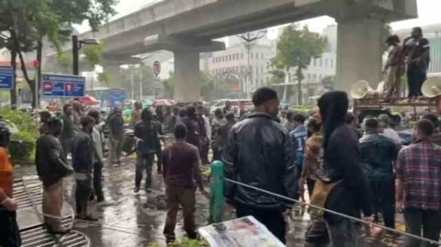 Puluhan massa aksi yang bertahan ditengah hujan deras di depan Kantor Kementerian HAM RI